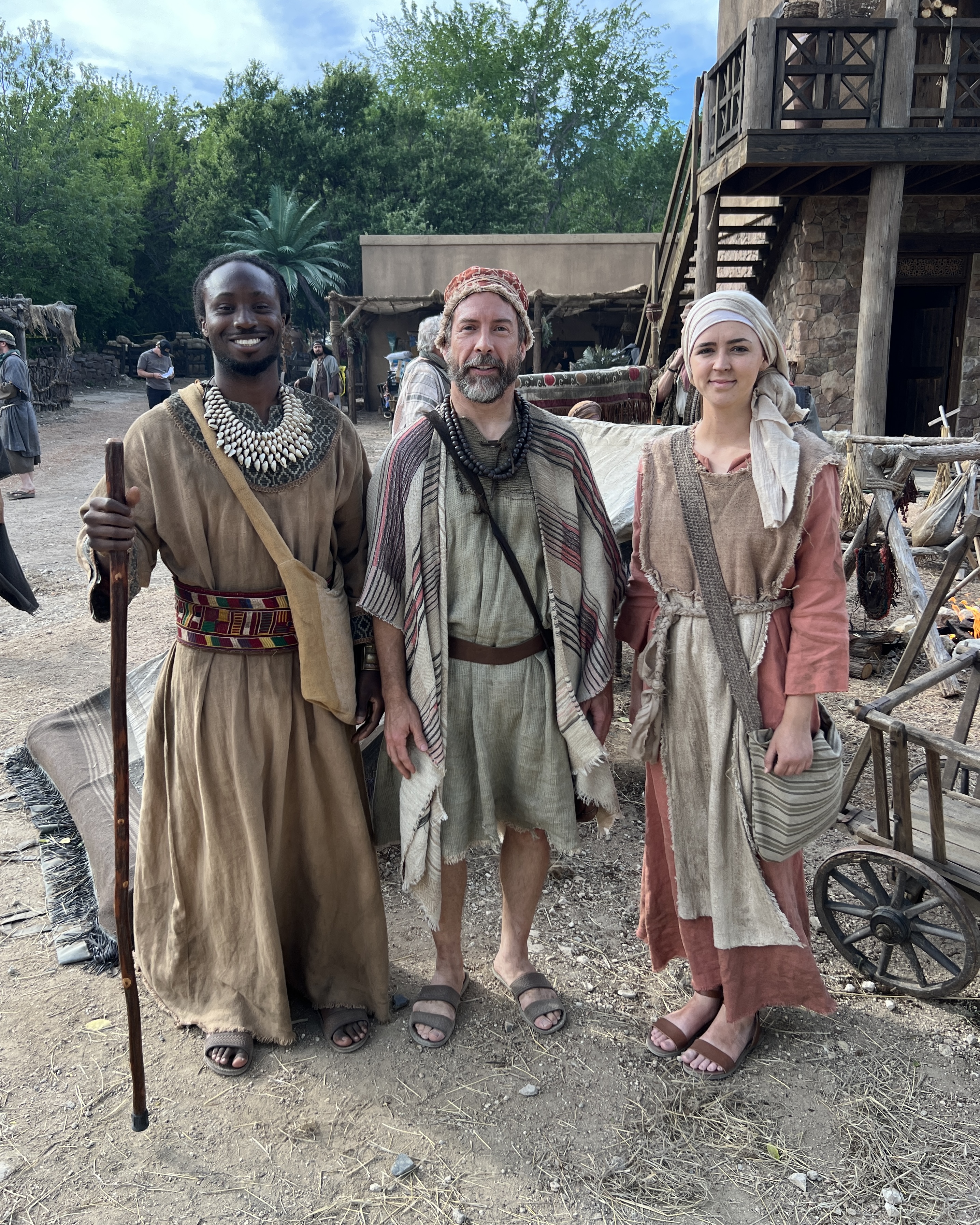 Three background actors dressed as citizens on the set of the show The Chosen.