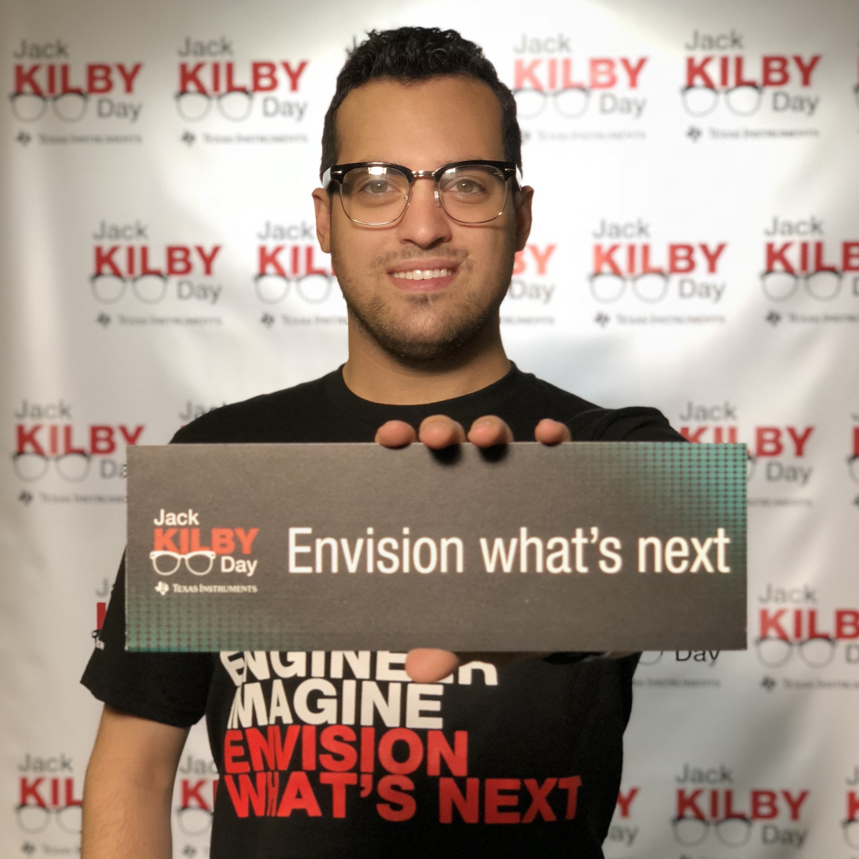 Handsome man with glasses holding a sign that says envision what's next.